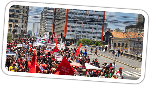 Manifestantes com bandeiras vermelhas atravessam uma ponte no centro do Recife durante o ato contra a escala 6x1, em novembro de 2024